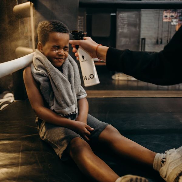 Sports bag with a water bottle, a towel, and comfortable training shoes.