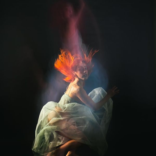 Woman performing a fluid cardio movement in a calm studio environment.